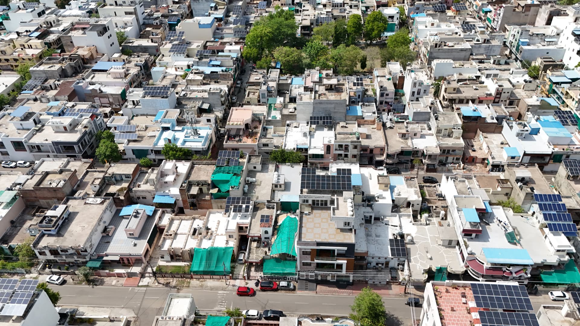 Aerial overview of a Rajasthan neighbourhood with dozens of Renewray solar installations visible on rooftops